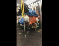 Orange shopping cart with trash bags on subway train