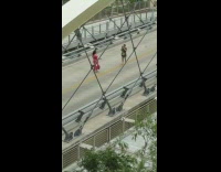 Lady in Pink Walks Back and Forth for Photo on Bridge 