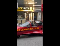 Man drive red aircraft shaped car on street
