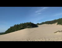 Toy car monster truck drives off sand dune and flies in the air