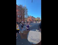 Woman holds power up sign at marathon