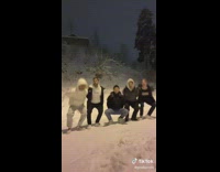 Group of five guys coordinated dance in the snow