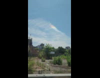 Long wispy clouds with small rainbow 