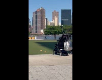 Guy rides bike balance wheel on head