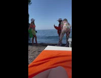 Woman in orange bikini poses on the beach