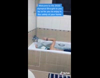 guy in swim cap swims in a bath tub