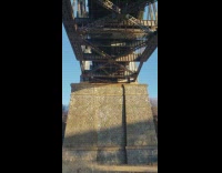 Guy jumps off bridge with red parachute