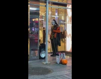 Guy wearing orange jacket uses resistance band 