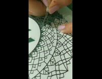 Girl uses knife to cut details into paper 