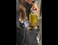 Girl holds jar of pickles in train 