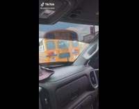 Guy puts bumper sticker on school bus