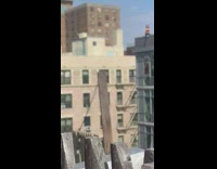 Woman sits on the edge of rooftop for a tiktok