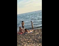 Woman in black bikini with white coverups poses at the beach