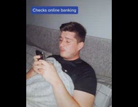 Black shirt guy checks online banking bed