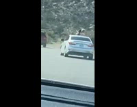 two girls stand sun roof silver car