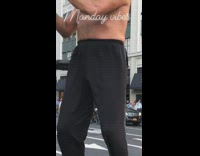 Shirtless guy black pants plays flute outside