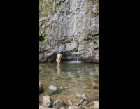 Girl poses next to small waterfall 
