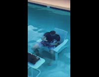 Guy in pool under water sitting and reading 