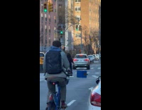 Guy rides bike drags newspaper box down
