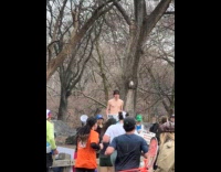 Shirtless man holds sign for NYC marathon