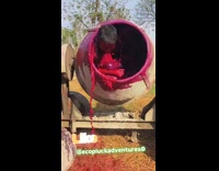 Man inside cement mixer machine with red dye