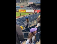 Woman grey jacket dances at Yankees stadium