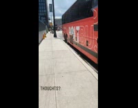 Big red bus idles at 3 minute idling lane on the curb