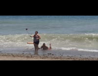 Lady orange pool noodle selfie stick beach