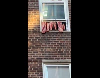 Raw meats hang outside the apartment window