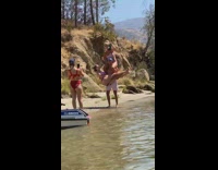 Man carries two women on the lakeshore