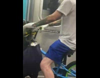 Guy rides bike on train wearing beak mask 
