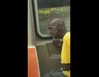 Man in yellow shirt shaves face with razor on the subway train