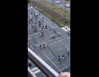 Large group of bicycle riders cross the street
