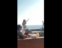 Two women bikini dances at beach restaurant