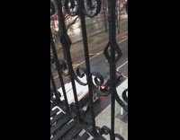 White bus honks black car black balcony 