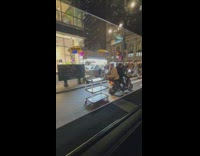 Guy pulls trolley while on a motorcycle 