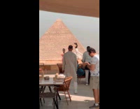Woman white skirt dances  front of pyramids