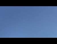 Two small white lights orbs blue sky 