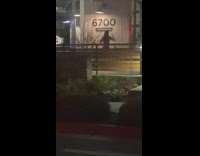 Woman films video in front of 6700 sign