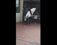 a man carrying a surfboard in a black wet suit