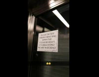 Guy on elevator with white warning sign 