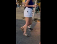 Dog keeps biting shoelace of walking woman