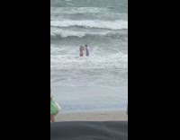 Man wet white polo video shoot beach