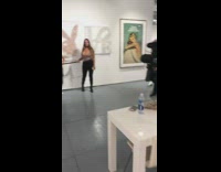 Two women take picture in front of Playboy bunny display