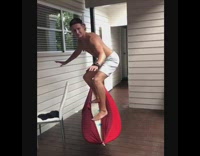 Collab Kook Of The Day - Guy balances on white surfboard red hammock