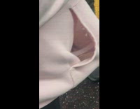 Guy pink hoodie has fish swimming in plastic container in his pocket on subway train