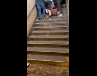Guys move refrigerator up the subway stairs