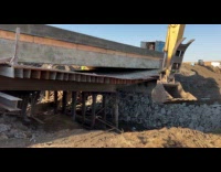 Excavator pull metal beam remove wood underneath bridge