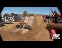 Guy jumps off red motorcycle dirt ramp 