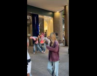 Three women in sports bra dances storefront
